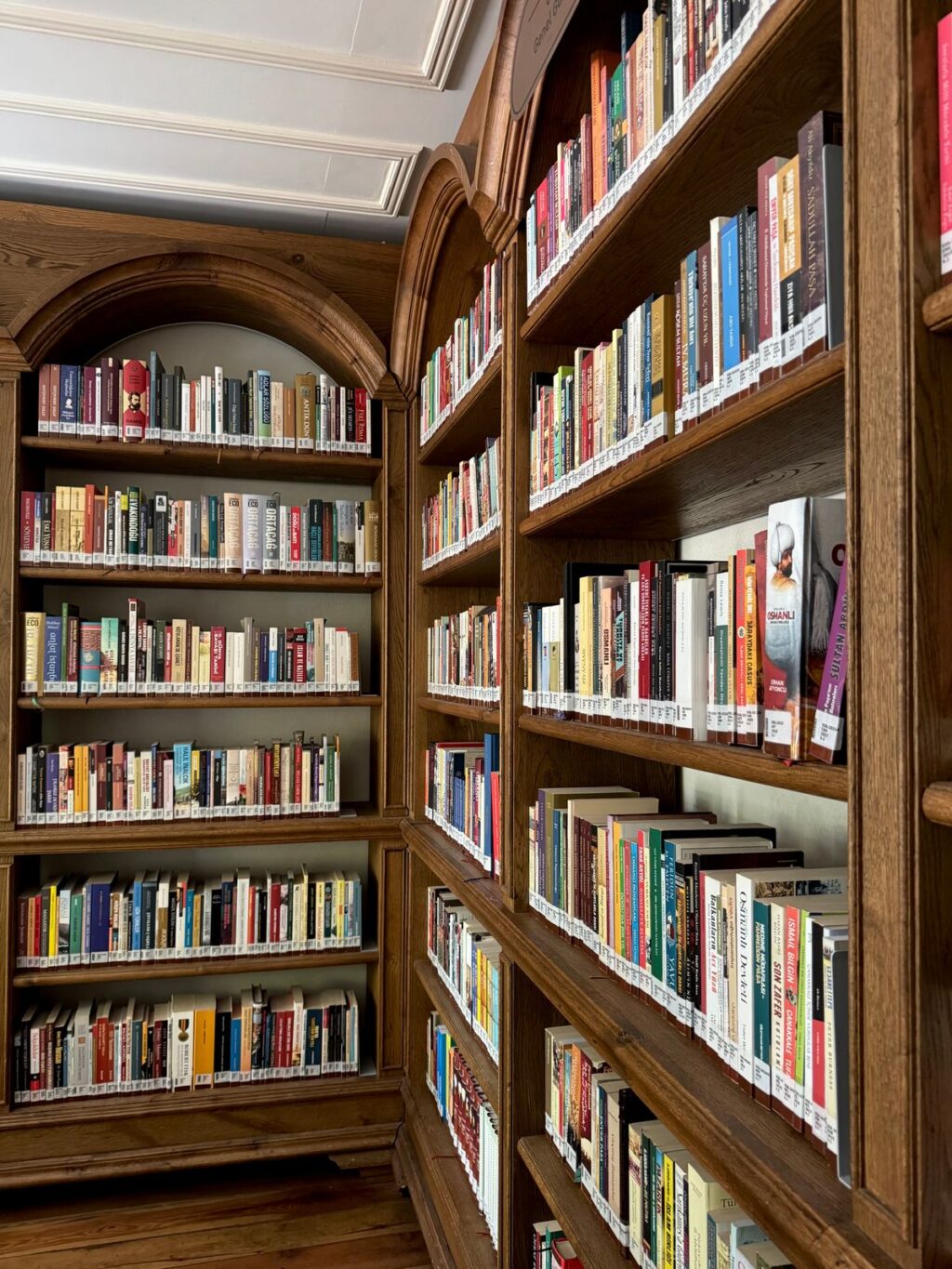Rafturi de bibliotecă cu volume vechi și un caiet deschis pe masă